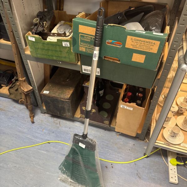 New extending handled broom with dark bristles for floor cleaning.