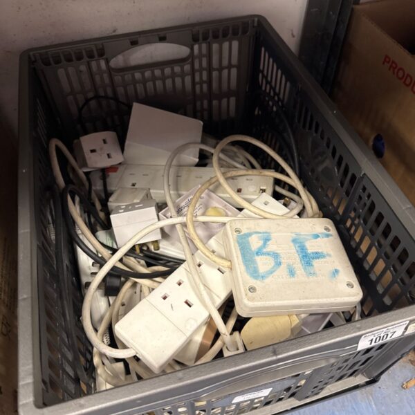 Tray of assorted extension leads and power strips for electrical connections.