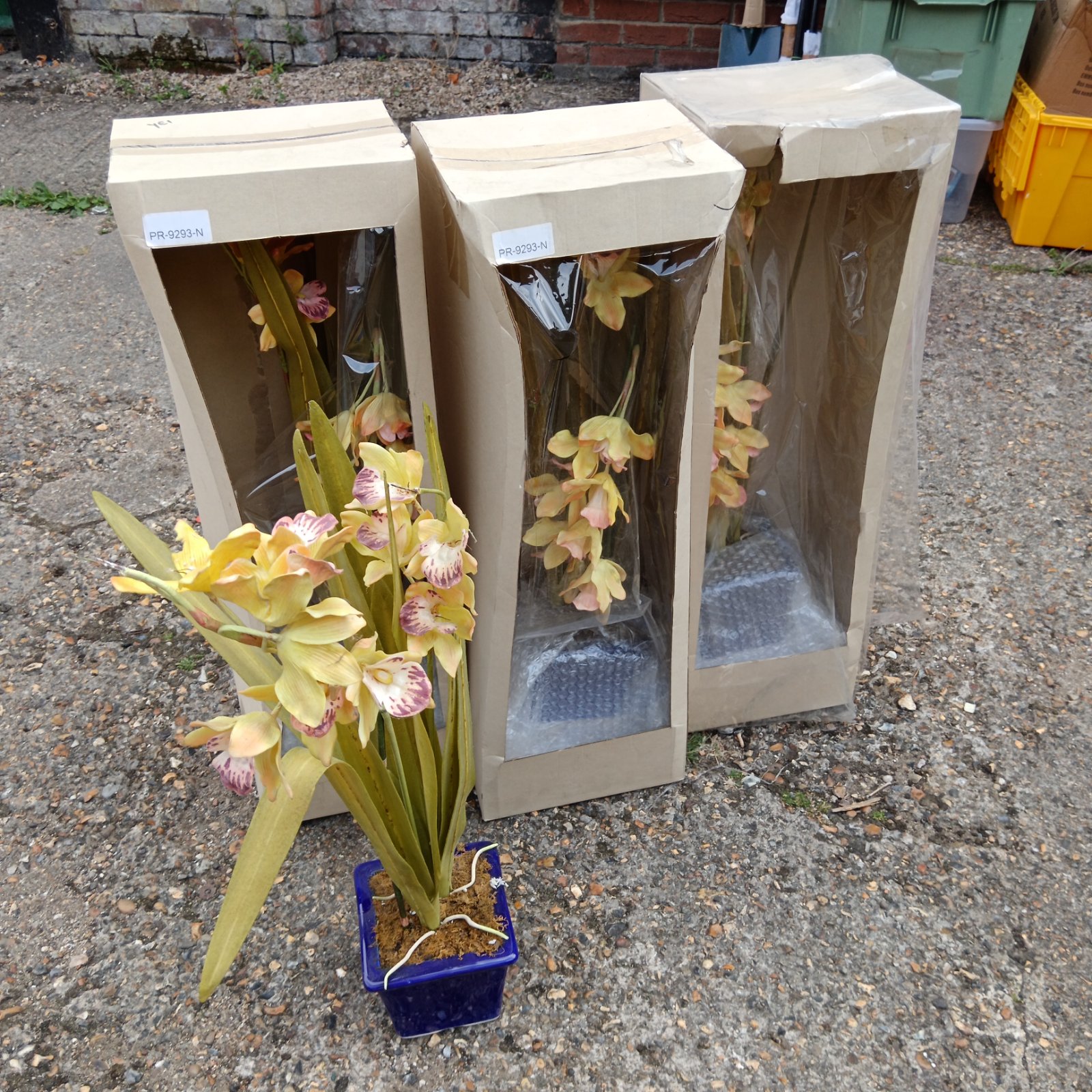 Four potted faux orchid plants, model PR923-N, in clear sleeves.