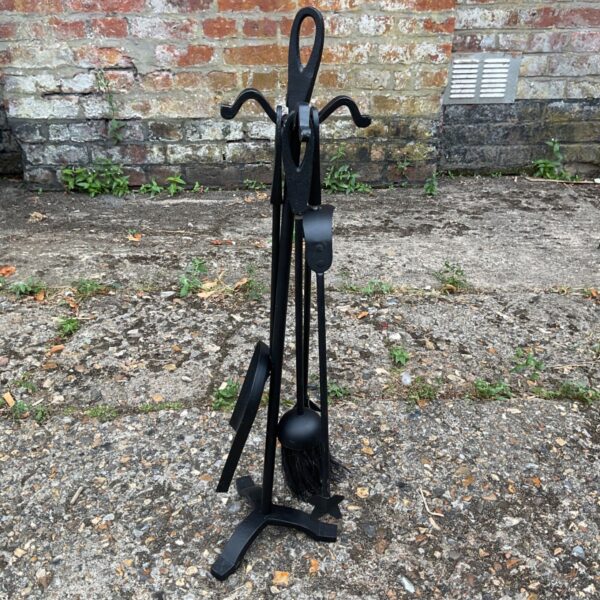 Black metal fireplace tool set with brush and poker.