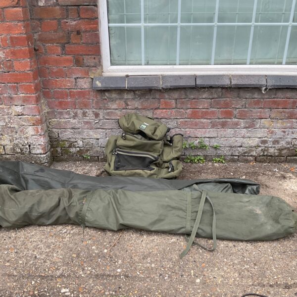 Fishing shelter set with Rod Hutchinson bag for angling trips.