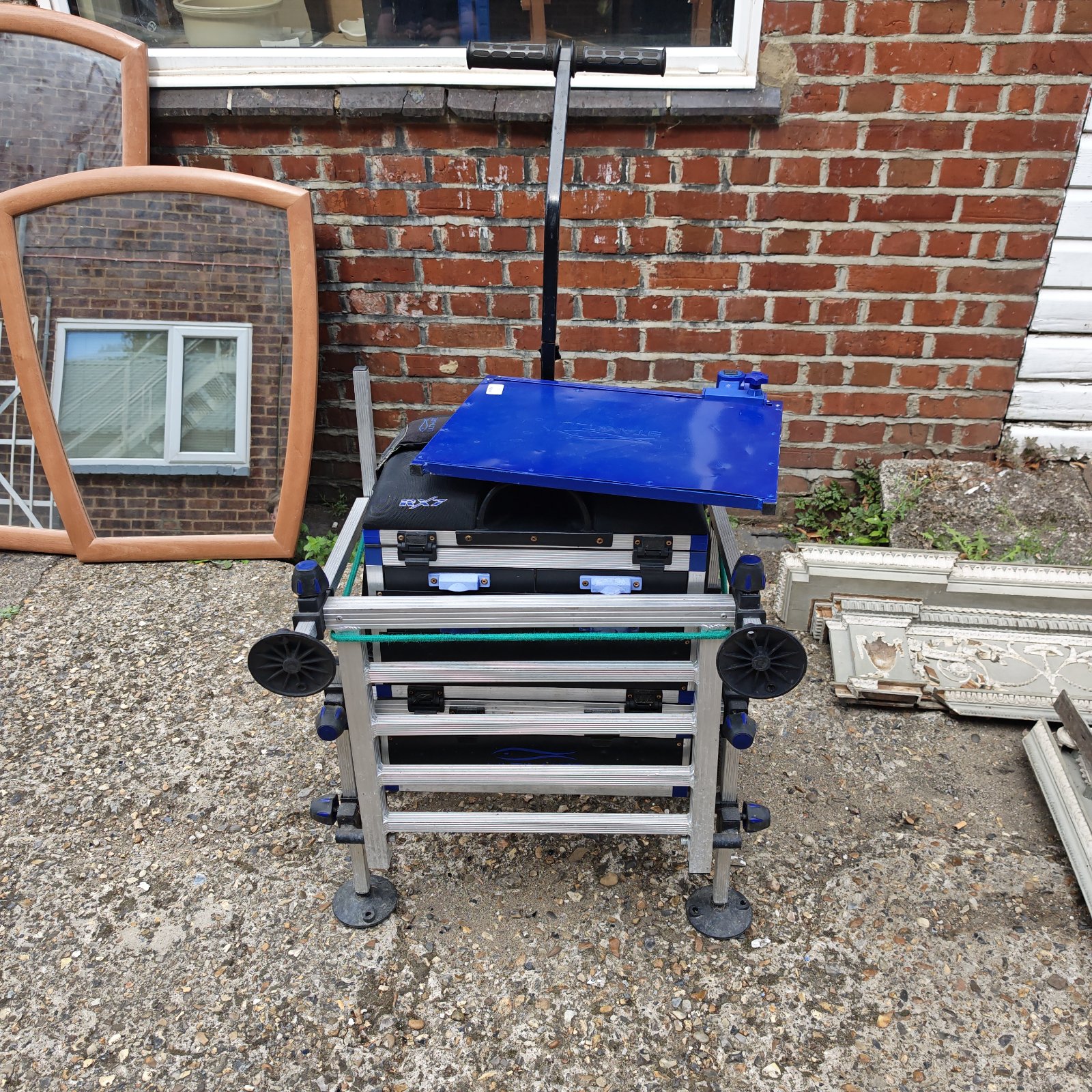 Blue fishing tackle seat box with adjustable legs and storage.