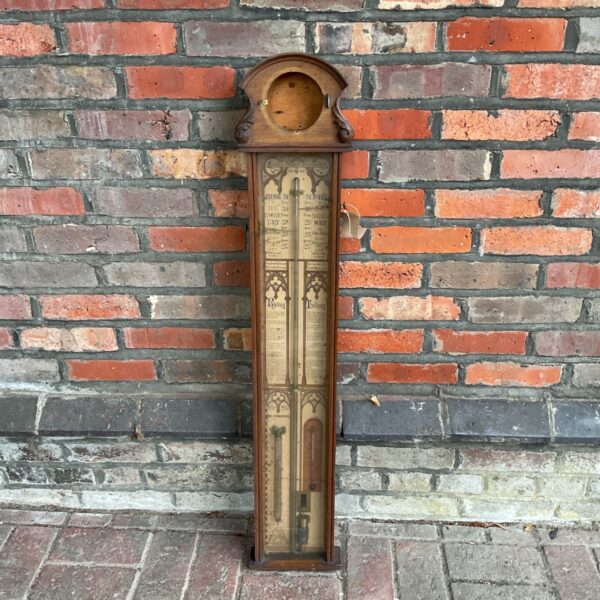 Antique Fitzroy barometer against brick wall.