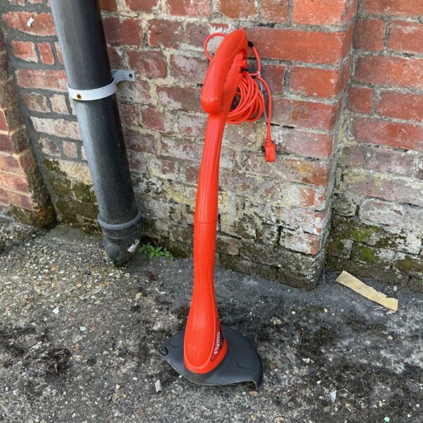 Red Flymo Mini Trimmer for garden edging and trimming.