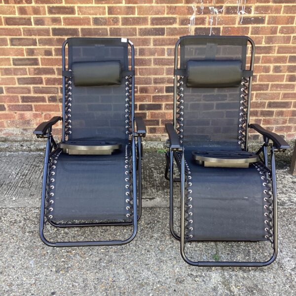Pair of black folding sun loungers with drinks holders.