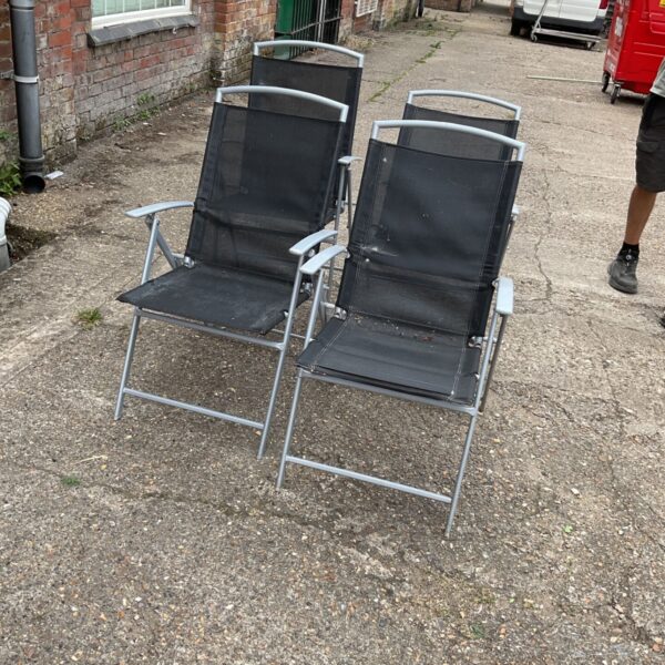 Four folding garden chairs with metal frames and mesh backs.