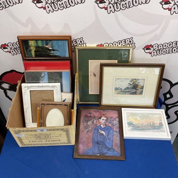 Assorted framed prints and empty picture frames in a box.