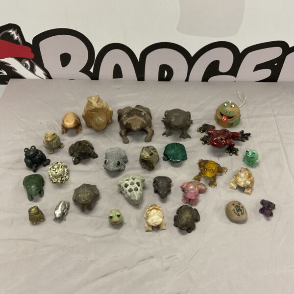 Collection of stone, metal and wooden frog and toad ornaments.