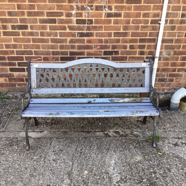 Vintage garden bench with wrought iron ends in a garden setting.