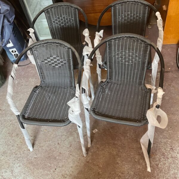 Set of four weathered garden chairs with metal frames.