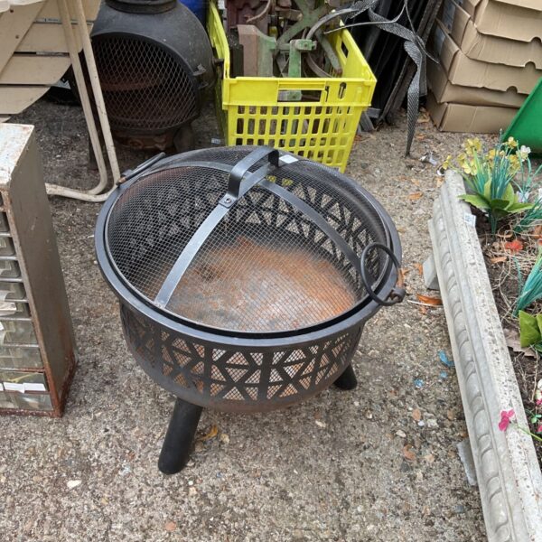 Dark metal garden fire basket with three legs.