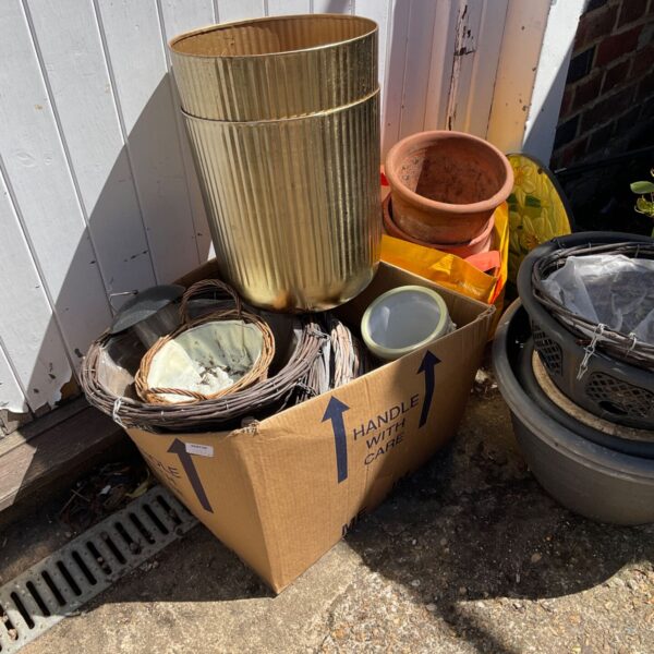 Selection of vintage garden pots and woven baskets for plants.