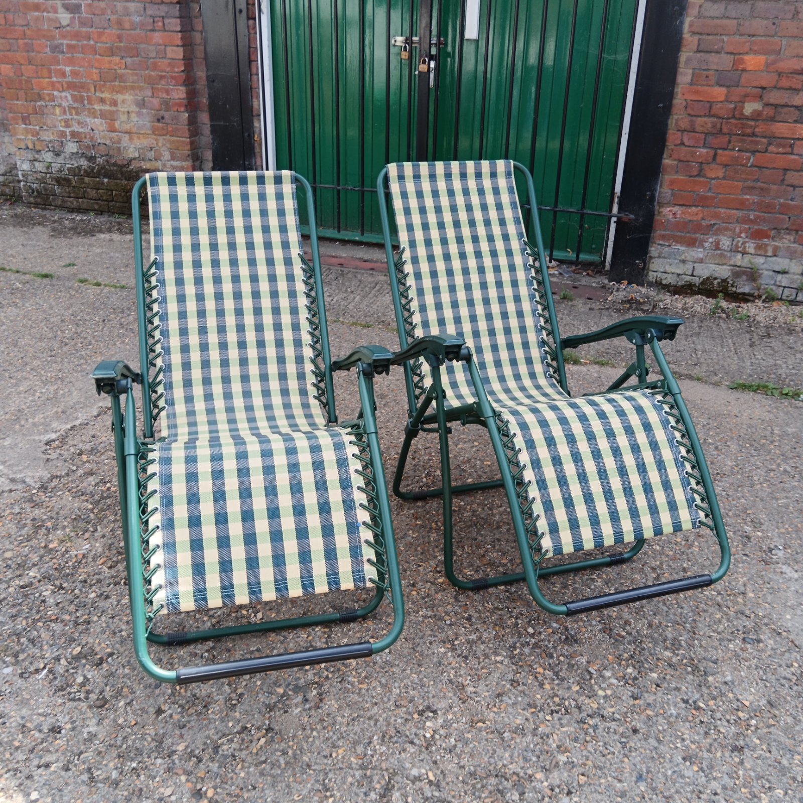 Two striped garden recliner chairs in a garden setting.