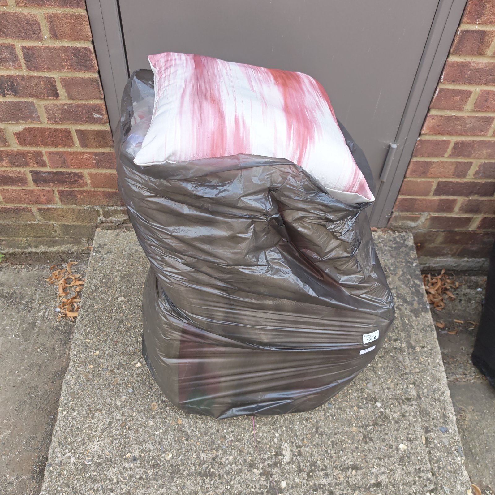 Black bag containing a lot of used garden seat cushions.