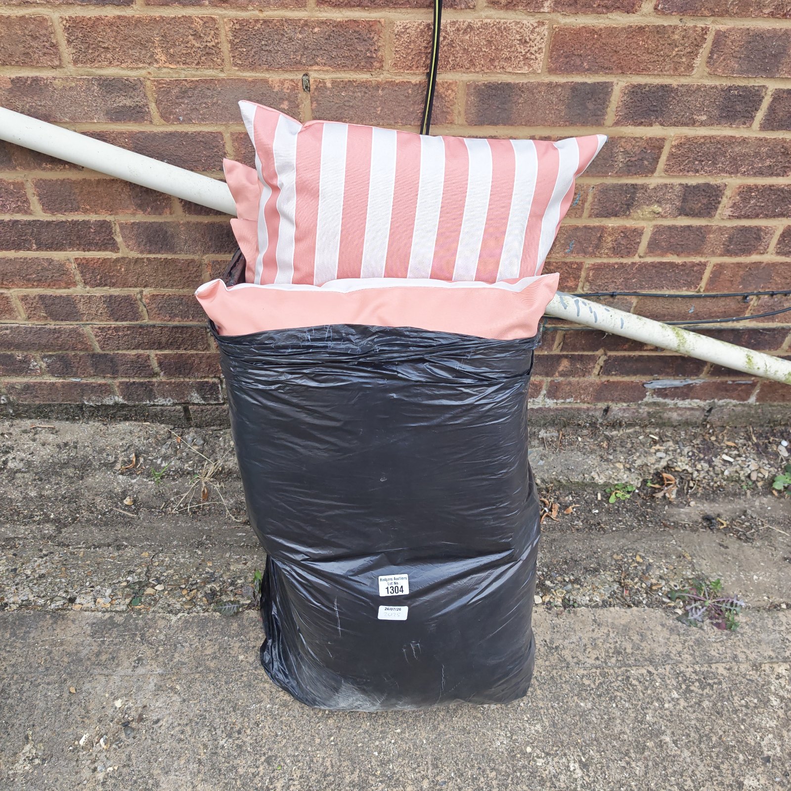 Striped garden seat cushions in a bag, showing signs of wear.
