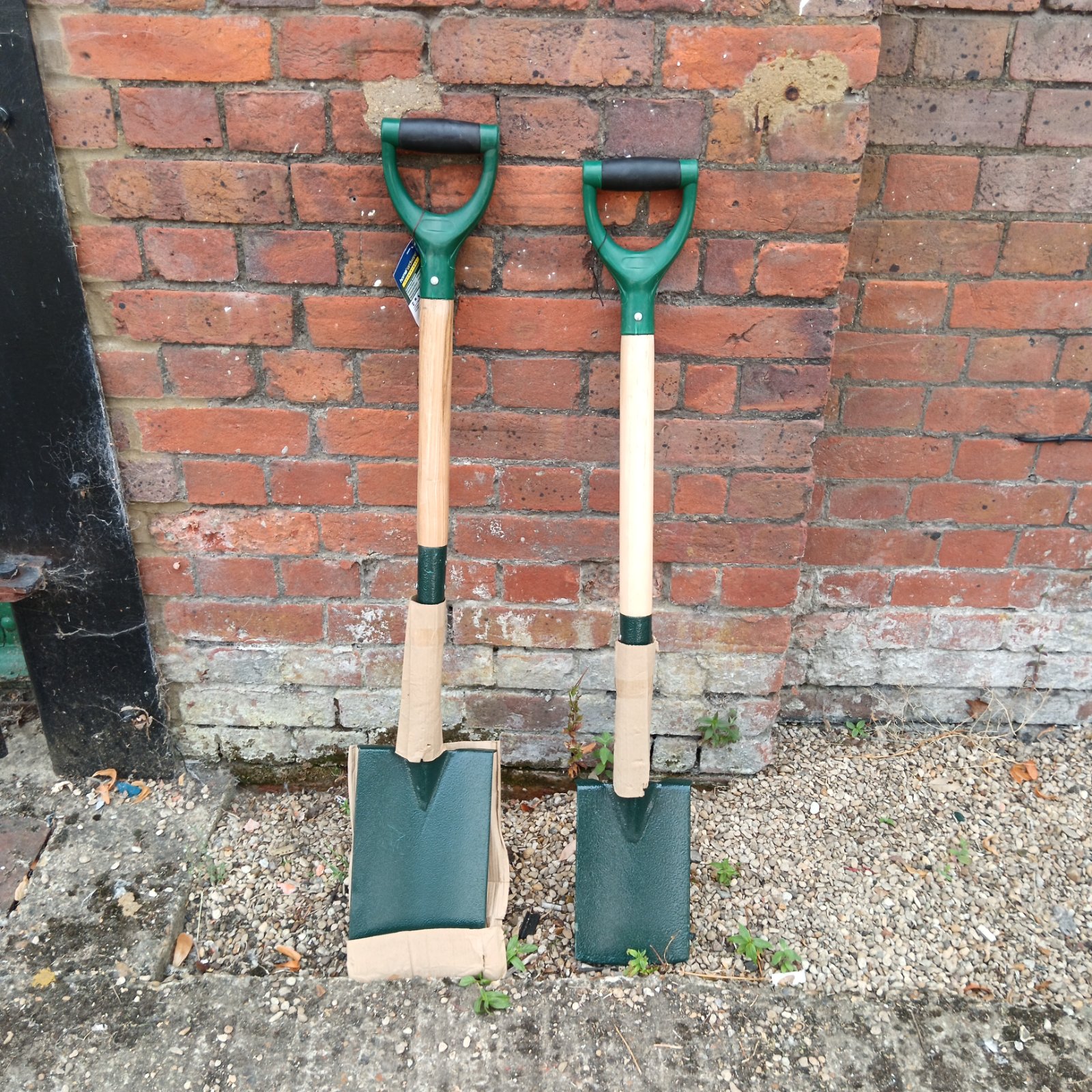 Pair of garden spades with wooden handles for digging and landscaping.