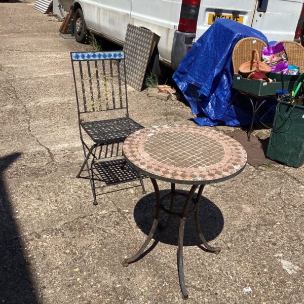 Vintage wrought iron garden table and chair set with mosaic tiles.