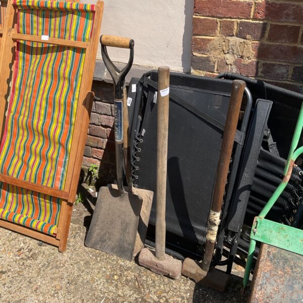 Assortment of vintage garden tools including shovels and sledgehammers.