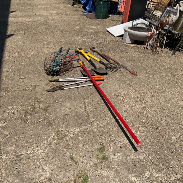 Selection of used garden tools including loppers and a spade.