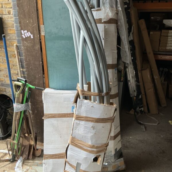 Boxed gazebo ready for assembly in a garden setting.
