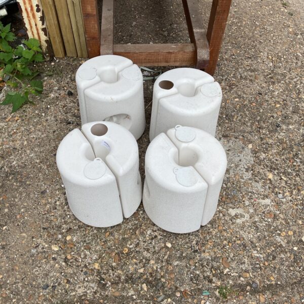 Set of four plastic gazebo weights for outdoor stability.