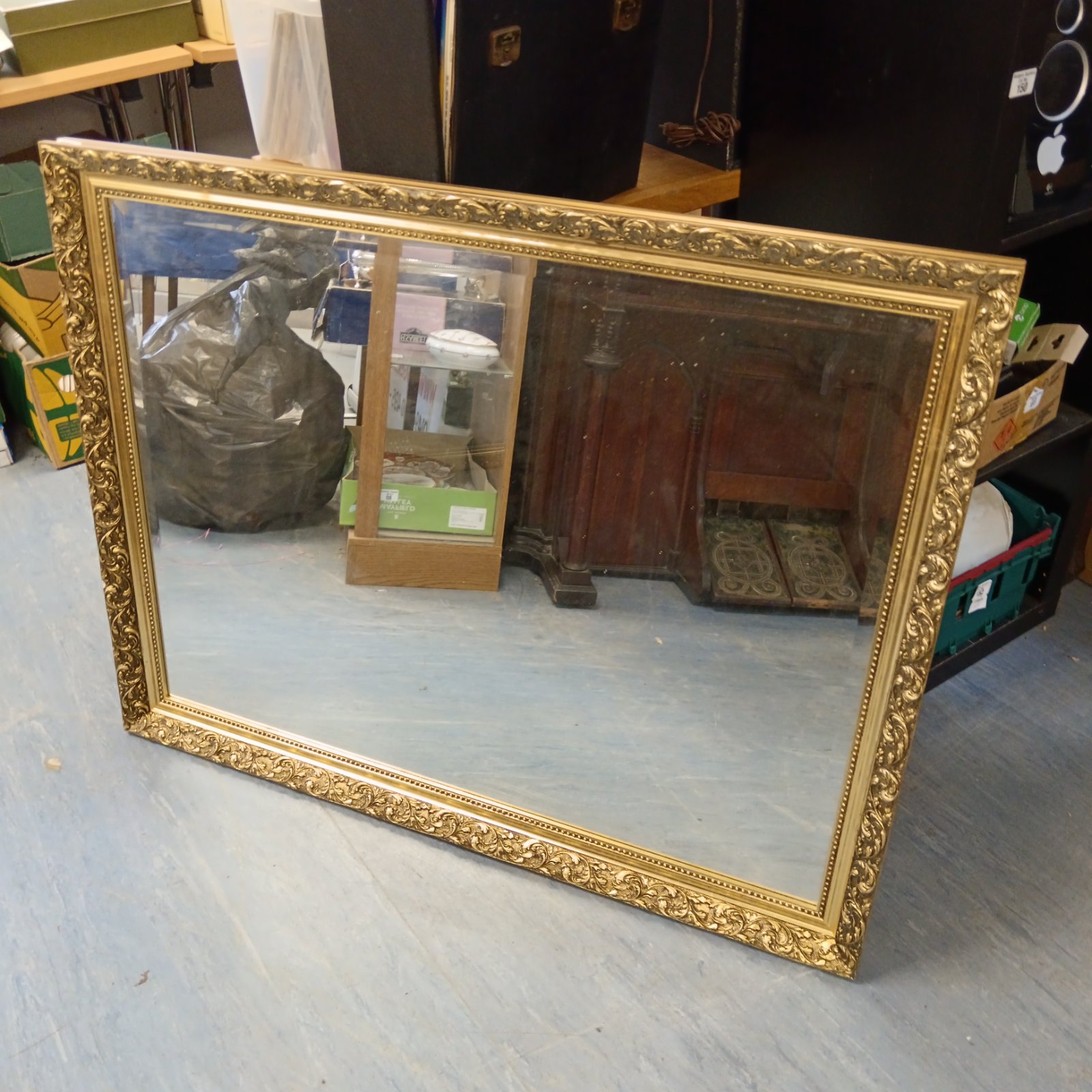 Large gilt framed bevel edge mirror for over a fireplace.