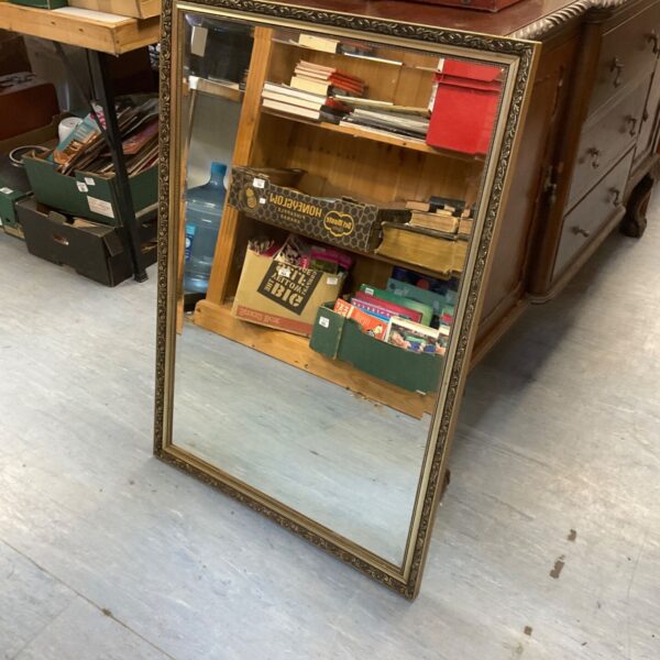 Vintage gilt framed bevel edge mirror with ornate gold detailing.