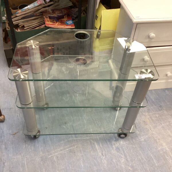 Silver metal frame glass media cabinet on casters.