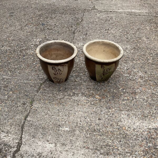 Pair of weathered glazed terracotta garden planters for outdoor use.
