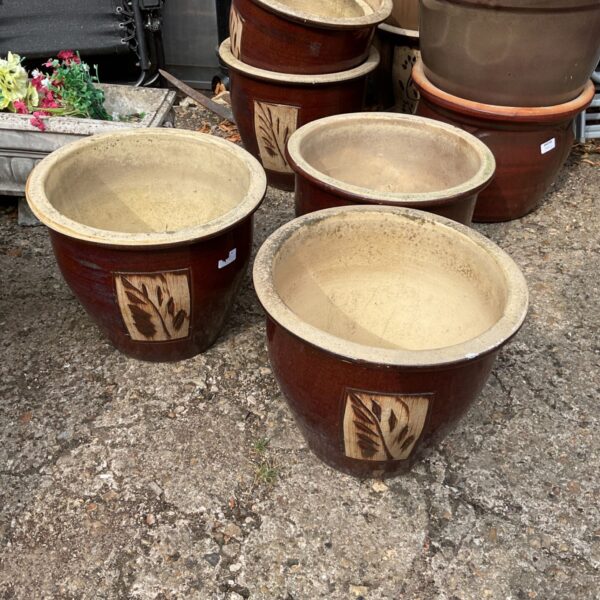 Stack of three glazed terracotta garden planters for outdoor use.