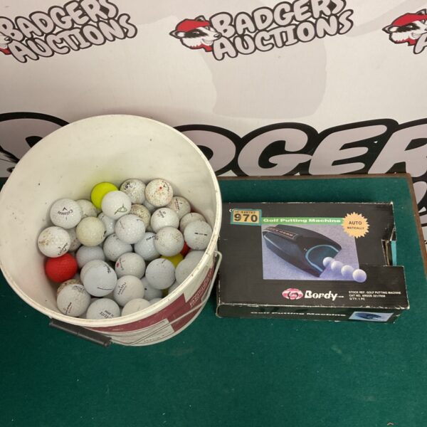 Bucket of used golf balls and a putting machine for golf practice.