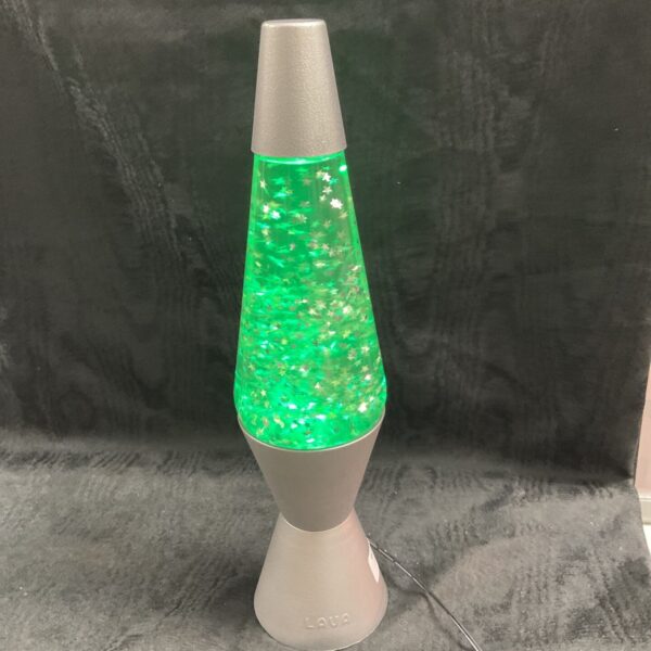 Green glitter lava lamp on a dark surface.