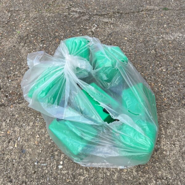 Green plastic jerry cans in a job lot, showing signs of use.