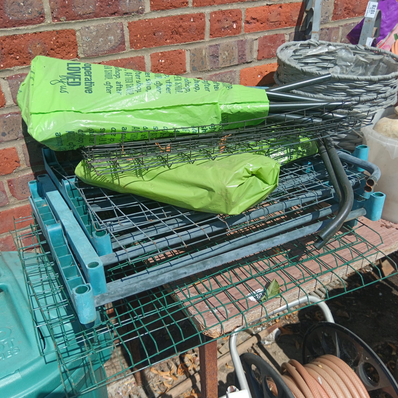 Metal greenhouse shelving unit with tiered wire mesh shelves.
