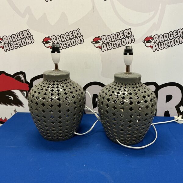 Pair of grey pierced porcelain table lamps for decorative lighting.