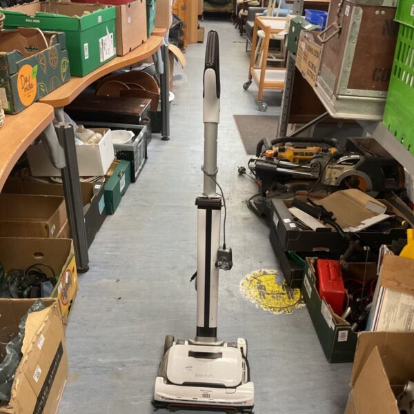 Used Gtech Airram 3 cordless vacuum cleaner in a cluttered space.