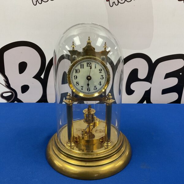 Vintage Gustav Becker 400-day clock with glass dome, brass case, and white dial.