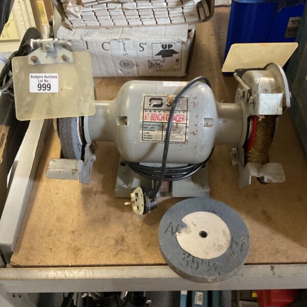 Heavy duty bench grinder with spare stone for workshop use.