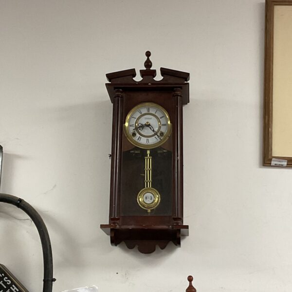 Vintage Highland wall clock with Roman numerals and pendulum.