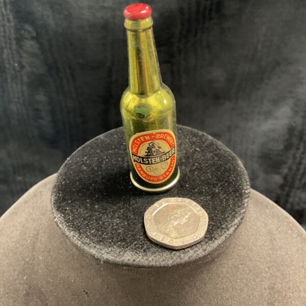 Vintage Holsten beer bottle petrol lighter on a grey surface.