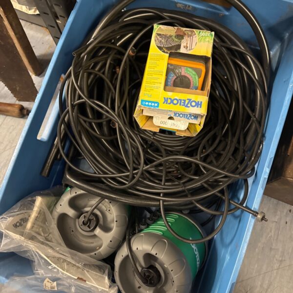 Hoselock garden watering system components in a plastic storage box.