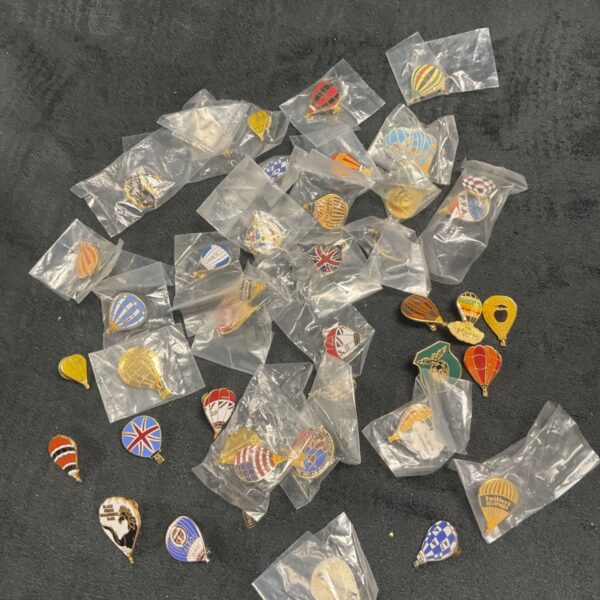 Large collection of colourful hot air balloon pin badges.