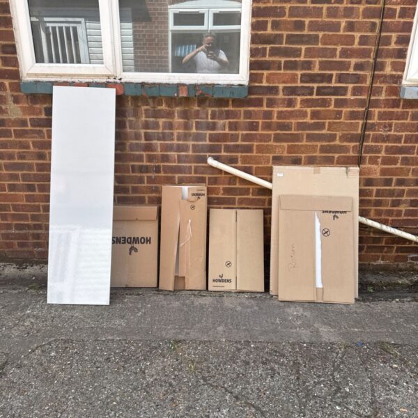 Howdens kitchen panels and doors stacked outside, showing damaged boxes.