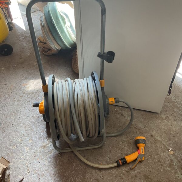 Grey Hozelock garden hose reel with spray nozzle attached.