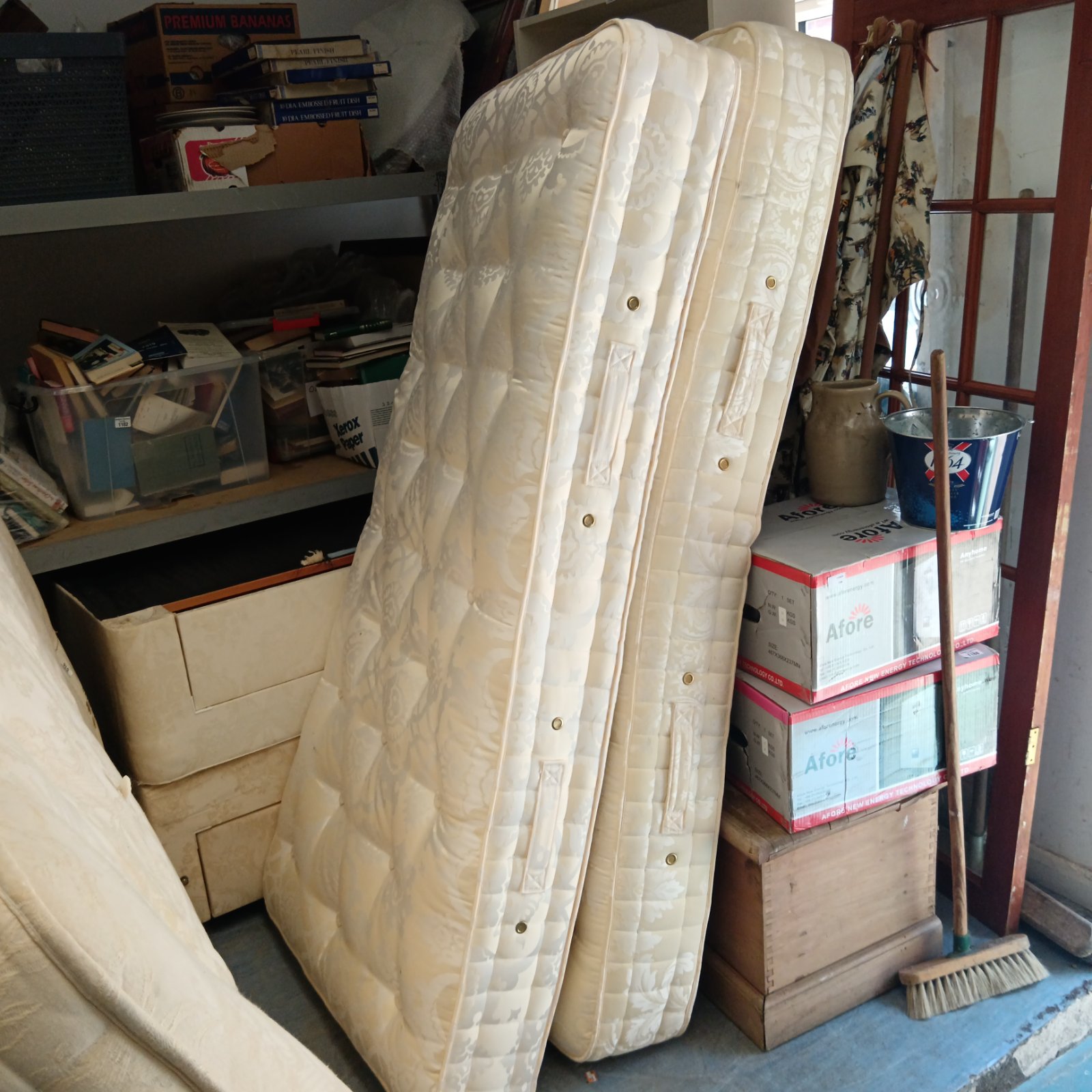 Two Hypnos single mattresses stored in a room.