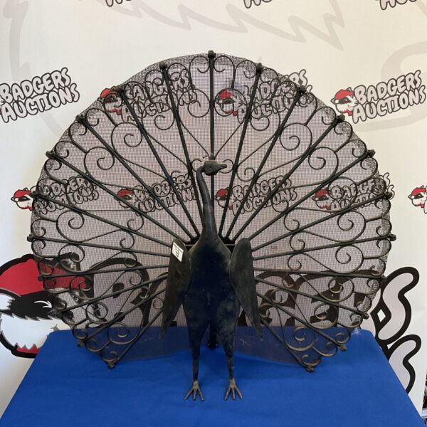 Vintage iron peacock fireguard with detailed metalwork.