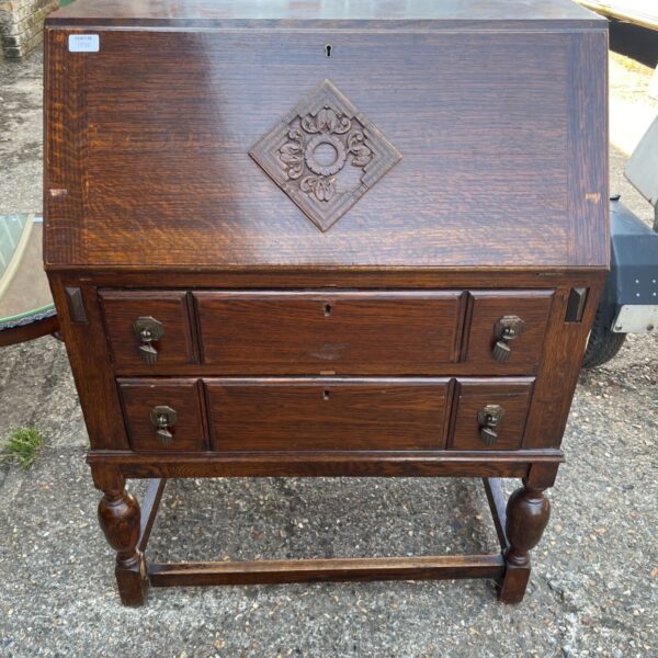 Antique Jacobean bureau desk with carved fall front and drawers.