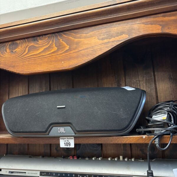 JBL OnBeat Venue wireless speaker with charger, side view.