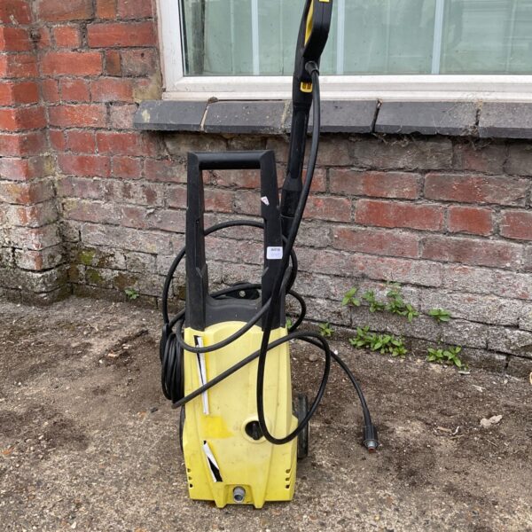 Yellow and black Karcher K3 pressure washer for garden cleaning.