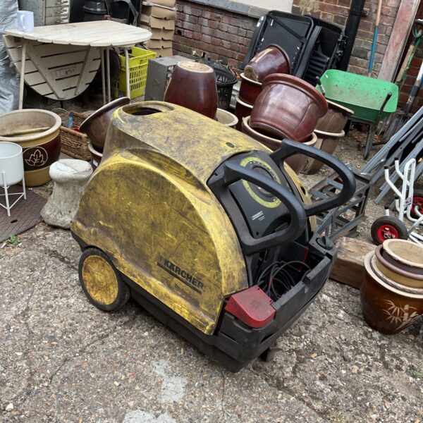 Yellow Karcher Professional power washer in a garden setting.